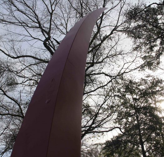 The Blade sculpture, a tall red four sided base that curves up to a point.